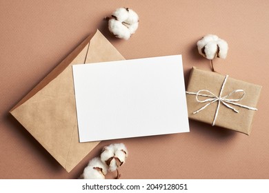 Invitation Or Greeting Card Mockup With Gift Box, Envelope And Natural Cotton Plant Flowers Decorations, Top View, Copy Space