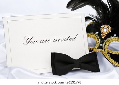 Invitation to mask party place on white satin