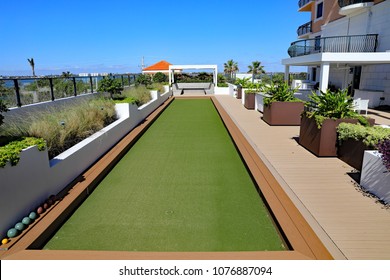 An Inviting Bocce Ball Court With Artificial Turf, On A Rooftop Terrace At A Condo In Florida.