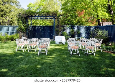 An inviting garden setting features white chairs arranged around a central table under a blue trellis.