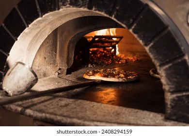 An inviting image capturing a pizza as it bakes in the glowing heat of a traditional brick wood-fired oven
