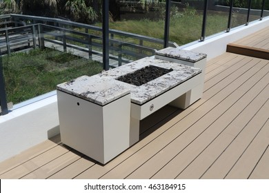 Inviting Modern Fire Pit On An Outdoor Terrace With Glass Surrounds.