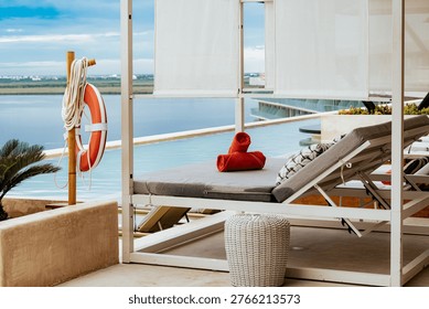 An inviting poolside setup featuring rolled red towels on a plush lounge chair, emphasizing relaxation, comfort, and the essence of a luxury getaway experience.