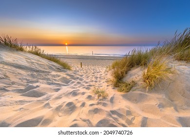 Inviting Sunset View over ocean from dune over North Sea and Canal in Ouddorp, Zeeland Province, the Netherlands. Outdoor scene of coast in nature of Europe.