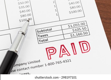 Invoice And Pen With Paid Stamp; Invoice Is Mock-up