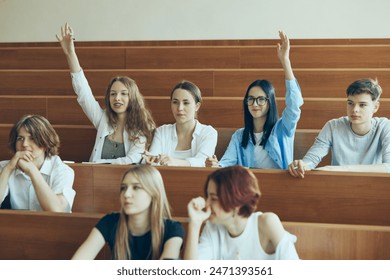 Involved students, girls raising hands to give answer during lecture. Students sitting in university classroom and learning new theme of subject. Concept of education, youth, workshop, knowledge - Powered by Shutterstock