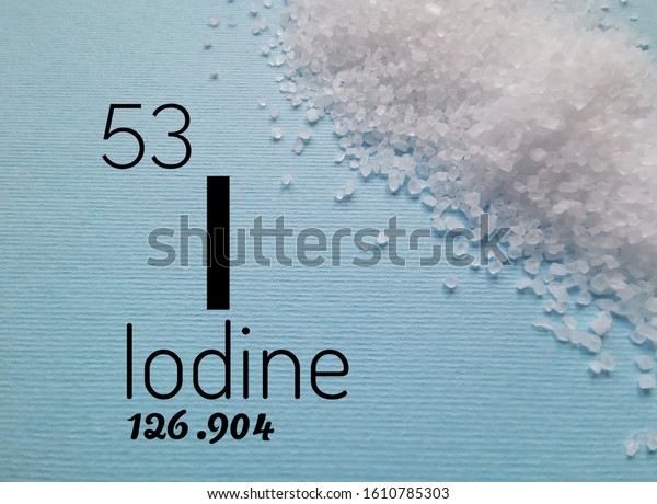Iodine is a chemical element of the periodic table. Symbol for the chemical element iodine with atomic data (atomic number, mass and electron configuration) and kitchen iodized salt in the background.