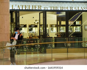 ION ORCHARD, SINGAPORE – 8 FEB 2020 – A Young Asian Chinese Shopper Wearing A Face Mask Outside L’Atelier By The Hour Glass, A Luxury Watch Boutique At Ion Orchard Shopping Mall