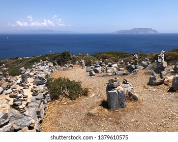 IOS ISLAND, GREECE, CIRCA JUNE 2018: The Ancient Homer’s Tomb With Blue Sky And Sea With Islands In The Background.