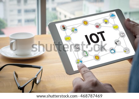IOT business man hand working and internet of things (IoT) word diagram as concept