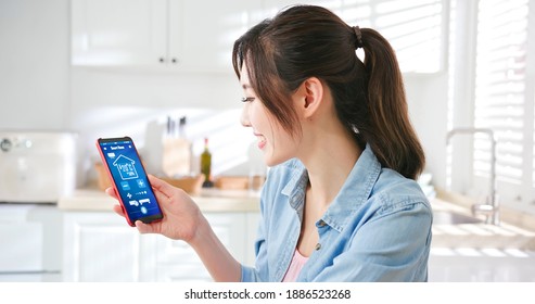 IOT smart home concept - asian young woman using app on mobile phone to control air conditioner temperature - Powered by Shutterstock