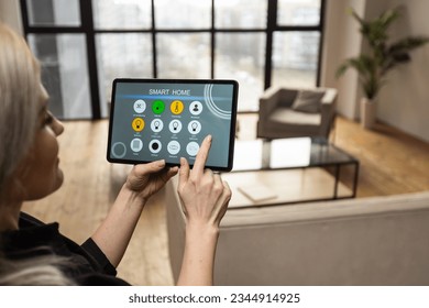 Iot Smart Home Concept - rear view of woman ask digital tablet to set temperature of air conditioner more higher by voice at home and all the electric meter in house getting energy-efficient - Powered by Shutterstock - Get 15% off with code: PIKWIZARD15
