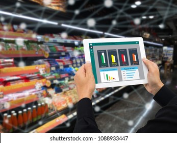 iot smart retail in the futuristic concept, the retailer hold the tablet and use augmented reality technology monitor data of out of shelve, price, planogram, campaign of compliance in the real time - Powered by Shutterstock