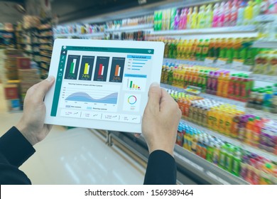 iot smart retail in the futuristic concept, the retailer hold the tablet and use augmented reality technology monitor data of out of shelve, price, planogram, campaign of compliance in the real time - Powered by Shutterstock