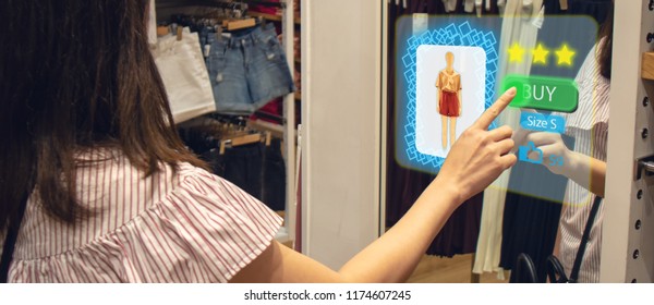 iot smart retail futuristic technology concept, happy girl try to use smart display with virtual or augmented reality  in the shop or retail to choose select ,buy cloths and give a rating of products 