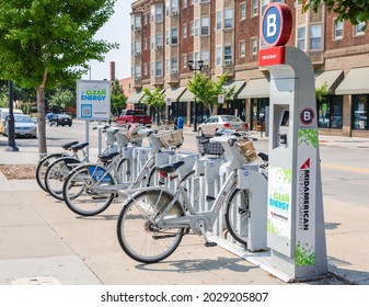 Iowa City, IA, USA-Aug 6, 2021: Bicycles Rental In A Row Of Parking Lot At Pavement Sidewalk. Public Rent Bike For Traveling And Free Of Carbon Dioxide Transportation Around City, Green Energy Station