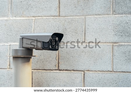 IP camera against a brick wall. Checking and controlling a barrier