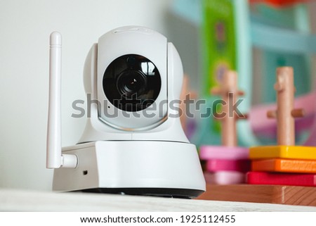 IP camera on the shelf with toys, serving as a baby monitor