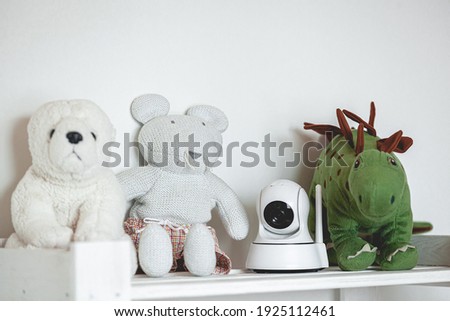 IP camera on the shelf with toys, serving as a baby monitor