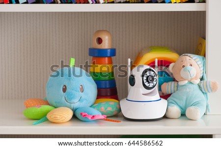 IP camera on the shelf with toys, serving as a baby monitor