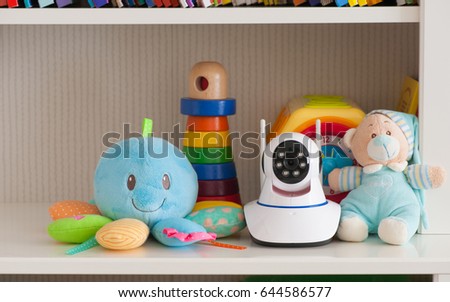 IP camera on the shelf with toys, serving as a baby monitor