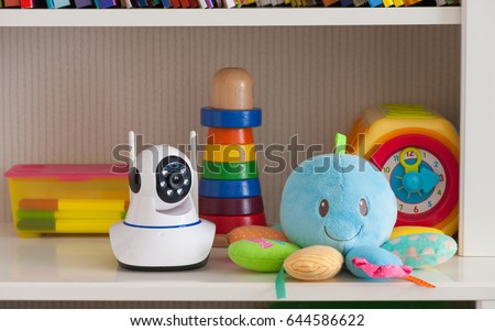 IP camera on the shelf with toys, serving as a baby monitor