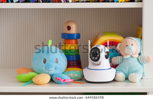 IP camera on the shelf with toys, serving as a\
baby monitor