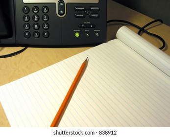 IP phone on the desk in the office with pencil and notepad