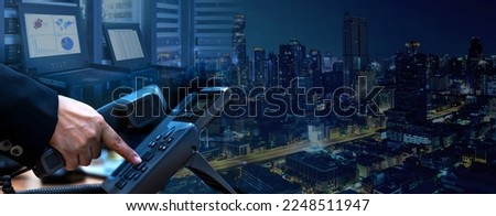 IP telephony management and telecommunications services system concept, business hand dialing ip telephone device, datacenter with rack servers and monitor, night cityscape background