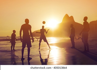 Ipanema Beach, Rio De Janeiro, Brazil, Silhouette Of Locals Playing Football At Sunset.