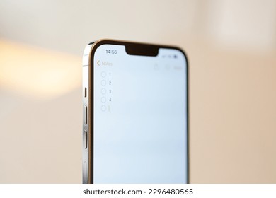 iPhone 13 pro max with notes app with to-do list on blurry background