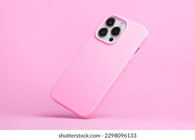 iPhone 14 pro max and 13 in pink soft silicone case falls down back view, phone case mockup in monochrome colours isolated on pink background