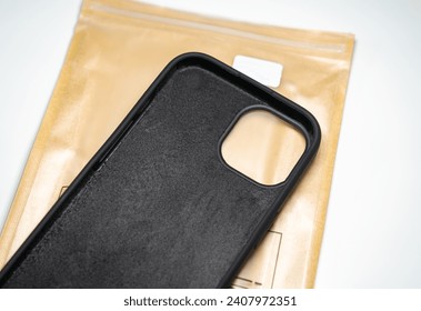 An iPhone 15 protective silicone case on a brown cover. White background.
