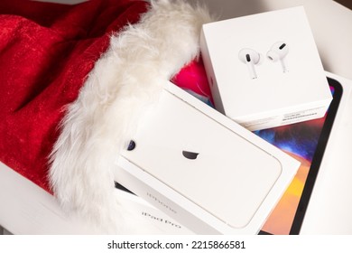 Iphone, Airpods Pro, IPad Pro Boxes In Santa Claus Hat. Gifts For Christmas And Happy New Year Concept. October 2022, Prague, Czech Republic