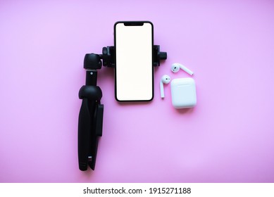 Iphone ,tripod Air Pods On Pink Background Mockup.Blogging 