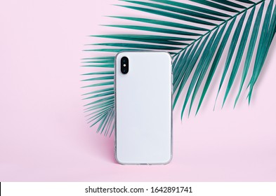 IPhone X In Clear Silicone Case Isolated On Pink Background With Palm Leaf Back View. Transparent Phone Case Mock Up