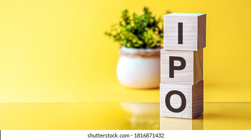 IPO - acronym from wooden blocks with letters, Initial Public Offering IPO concept, yellow background.Words: IPO in 3d wooden alphabet letters on a bright yellow background with copy space.