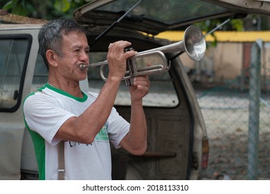 Ipoh, Malaysia - January 17th,2021 : Old Man Entertains Tourists Playing The Trumpet At The Pasar Karat In Ipoh.