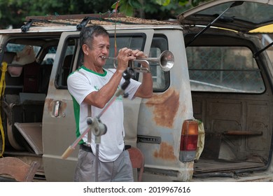 Ipoh, Malaysia - January 17th,2021 : Old Man Entertains Tourists Playing The Trumpet At The Pasar Karat In Ipoh.