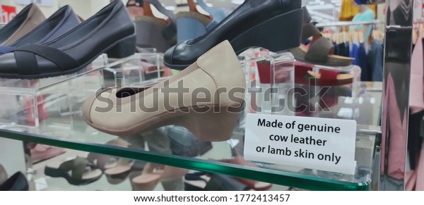 Ipoh, Malaysia - July 8, 2020 : Close-up shot of\
notifications to customer. That info is to let customer know\
material that shoes maker using to produce the shoes is original\
cow leather or lamb skin.
