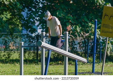 IPOH, MALAYSIA - October 10, 2022 : A Group Of Elderly People And Children Using Exercise Equipment In The Park On A Sunny Morning.