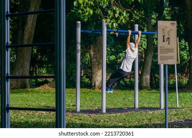 IPOH, MALAYSIA - October 10, 2022 : A Group Of Elderly People And Children Using Exercise Equipment In The Park On A Sunny Morning.