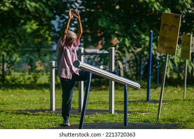 IPOH, MALAYSIA - October 10, 2022 : A Group Of Elderly People And Children Using Exercise Equipment In The Park On A Sunny Morning.