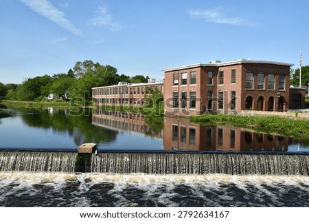 Ipswich River flowing over the dam at EBSCO in Ipswich, Massachusetts, on a beautiful June morning