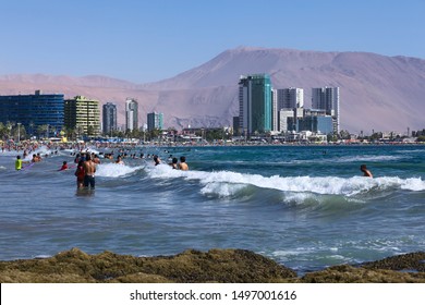 IQUIQUE, CHILE - FEBRUARY 10, 2015: Unidentified people bathing in the Pacific ocean at Cavancha beach on February 10, 2015 in Iquique, Chile. Iquique is a popular beach town in Northern Chile.