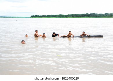 Iquitos, Peru; March 05, 2019. Children Of An Indigenous Amazonian Tribe Playing And Bathing In The Water Of The Amazon River.