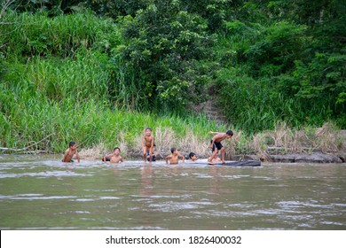 Iquitos, Peru; March 05, 2019. Children Of An Indigenous Amazonian Tribe Playing And Bathing In The Water Of The Amazon River.