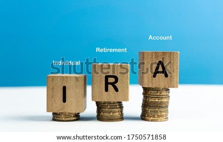 IRA Individual Retirement Account text on wood cube block stack with coins