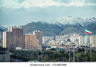 Iran Flag And Tehran City Skyline Against Snow Covered Alborz Mountains