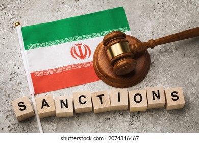 Iranian flag, judge's gavel and wooden cubes with text, concept on the topic of sanctions in Iran
